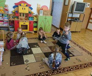 Zdjęcie przedstawia dzieci bawiące się na dywanie.