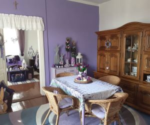 Wnętrze domu, Fioletowa ściana, wiklinowe meble, wystrój w starym stylu.