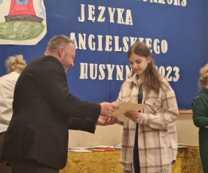 Pan Inspektor oświaty wręcza uczennicy dyplom i nagrodę