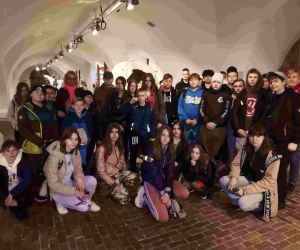 Uczniowie z nauczycielami na wspólnej fotografii na tle eksponatów w Muzeum Arsenał