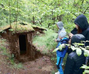 Uczniowie w lesie obok ziemianki