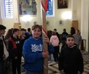 Uczeń trzyma w dłoniach zabytkową świecę tyszowiecką