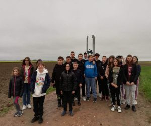 Uczniowie stoją na tle pomnika w Woli Śniatyckiej