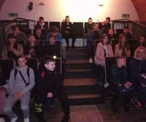 Uczniowie siedzą na widowni w Muzeum Arsenał