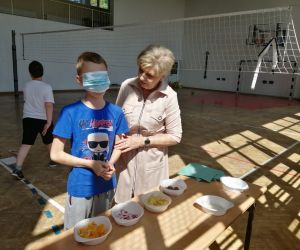 sala gimnastyczna, uczeń  z opaską na oczach zgaduje potrawy