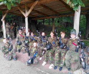 Chłopcy i dziewczęta w mundurach i z pistoletami z farbą