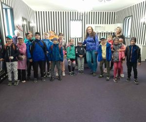 Uczniowie z nauczycielkami wewnątrz odwróconej chatki