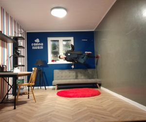 Uczeń stoi na jednej nodze na ścianie w pokoju