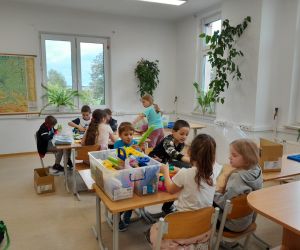 Uczniowie klasy drugiej przy stolikach budują konstrukcje z klocków