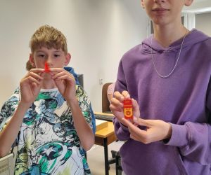 Uczniowie prezentują wydruk 3D postaci Mario oraz Breloka