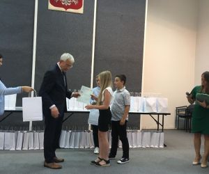 Uczennica odbiera upominek od senatora