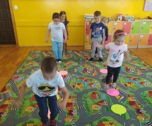 dzieci skaczą po okrągłych papierowych kołach