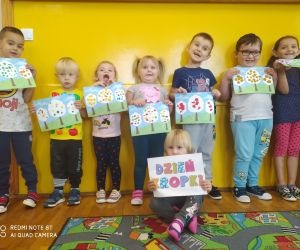 dzieci trzymają prace plastyczne - kropkowe drzewa