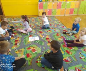 dzieci siedzą na dywanie