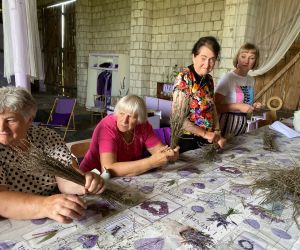 uczestniczki warsztatów robią coś z suszonych gałązek lawendy