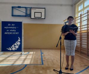 Przewodnicząca Rady Rodziców przy mikrofonie składa życzenia nauczycielom