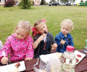 Trzy dziewczynki przy stole podczas poczęstunku