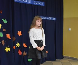 Zdjęcie przedstawia recytującą dziewczynkę.