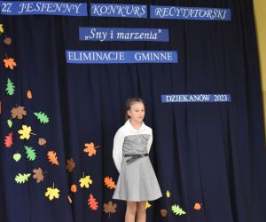 Zdjęcie przedstawia dziewczynkę recytującą wiersz.