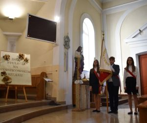 Chłopiec i dwie dziewczynki - szkolny poczet sztandarowy wewnątrz kościoła w Czerniczynie