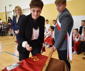 Przewodnicząca Rady Rodziców przybija gwóźdź pamiątkowy do drzewca sztandaru szkoły
