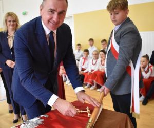 Pan Wójt Gminy Hrubieszów przybija gwóźdź pamiątkowy do drzewca sztandaru szkoły