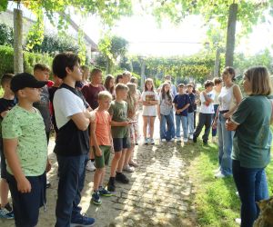 Uczniowie polscy i portugalscy słuchają przewodniczki na farmie ekologicznej