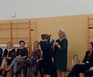 Nauczycielka przyjmująca   medal.