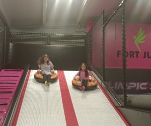 Uczennice zjeżdżają w parku trampolin.