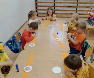 Przedszkolaki wykonują dyniowe opaski na głowę.