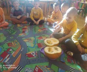 przedszkolaki oglądają dynię przekrojoną na pół