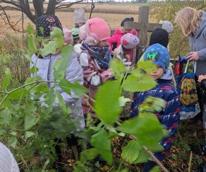 Uczniowie zapalają znicze na mogile