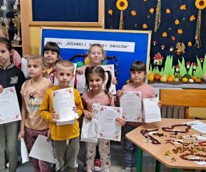 Nauczyciel z dziećmi prezentuje się z dyplomami