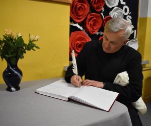 Proboszcz parafii pw. Ducha św. dokonuje wpisu w księdze pamiątkowej