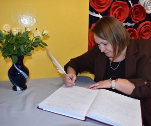 Przewodnicząca Koła Gospodyń dokonuje wpisu w księdze pamiątkowej