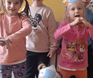 Dzieci stoją w opaskach z kredkami