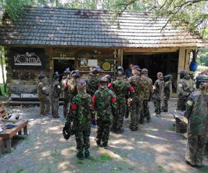 Uczniowie w mundurach polowych stojący tyłem słuchają instrukcji prowadzącego