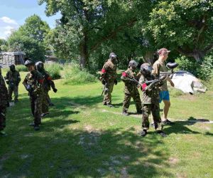 Uczniowie w mundurach polowych udają się na poligon