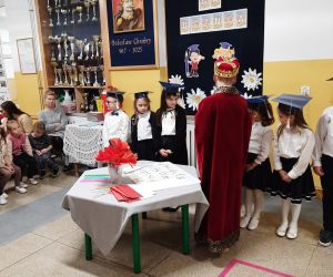 Chłopiec przebrany za króla wręcza uczniom zdobytą kredkę