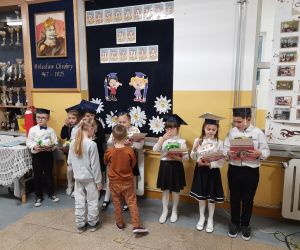 Przedszkolaki wręczają pierwszakom prezenty