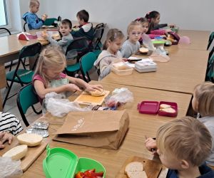 Dzieci jedzą wspólnie śniadanie.