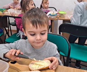 Chłopiec smaruje chleb.