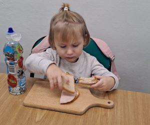 Dziewczynka układa chlebek na desce.