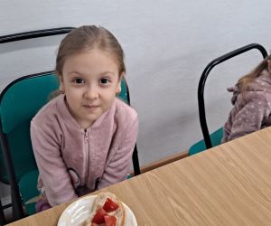 Dziewczynki prezentują swoje samodzielnie przygotowane kanapki.