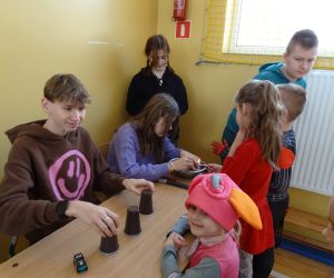 Uczniowie klas starszych przy stoliku wróżą młodszym uczniom