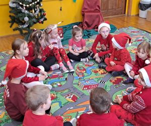 Dzieci siedzą w kółeczku.