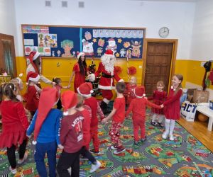 Dzieci tańczą z Mikołajem i jego pomocnicami