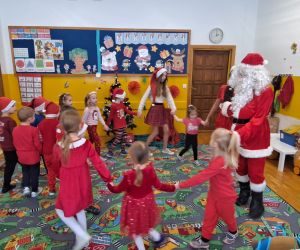 Dzieci tańczą z Mikołajem i jego pomocnicami