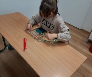 Dziewczynka pracuje na krośnie