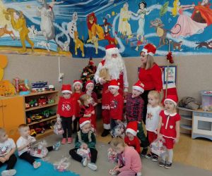 Mikołaj stoi wśród dzieci z punktu przedszkolnego